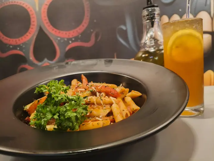 Golden-seared plate with herb garnish under warm neon light